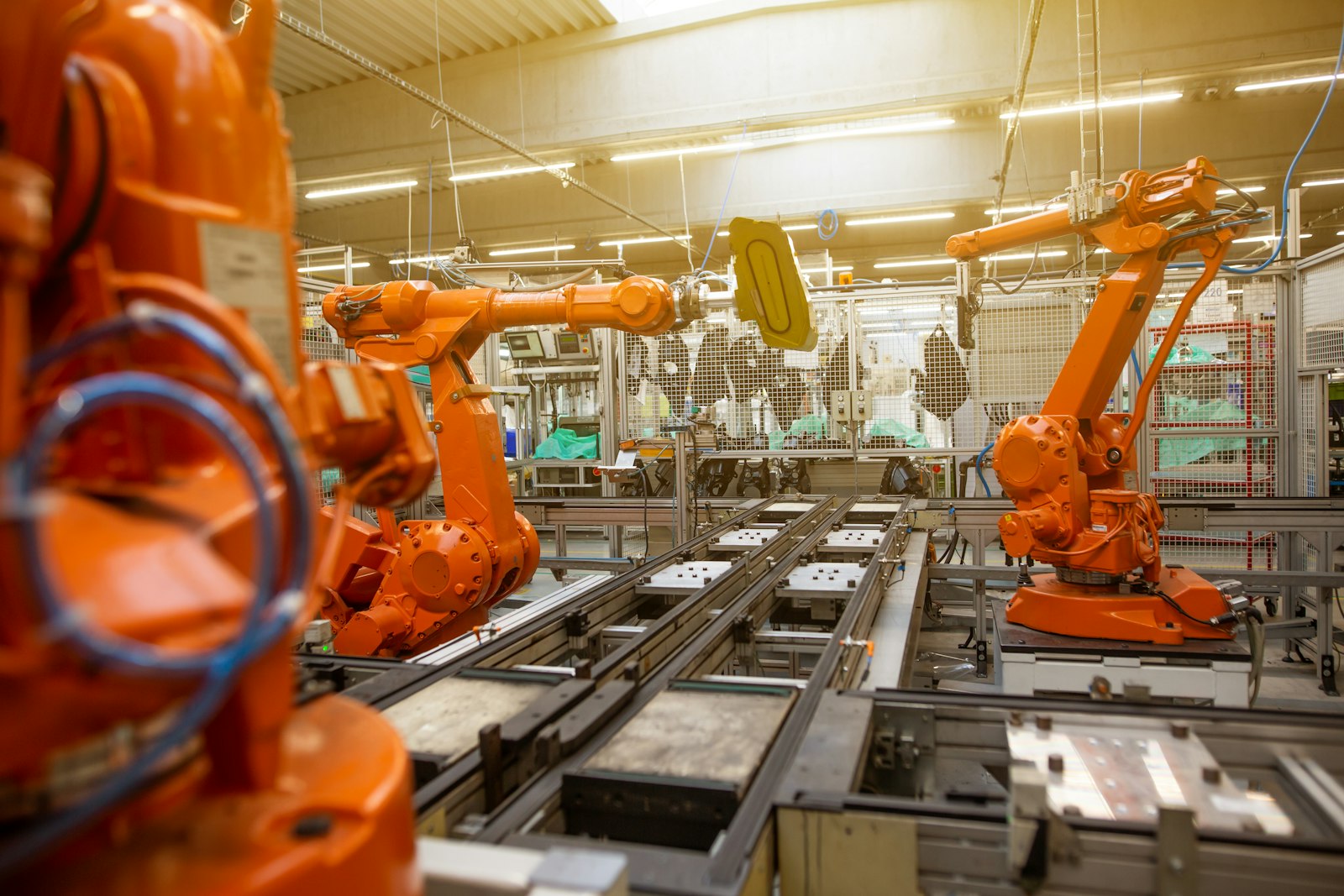 Pomarańczowe roboty przemysłowe na linii produkcyjnej